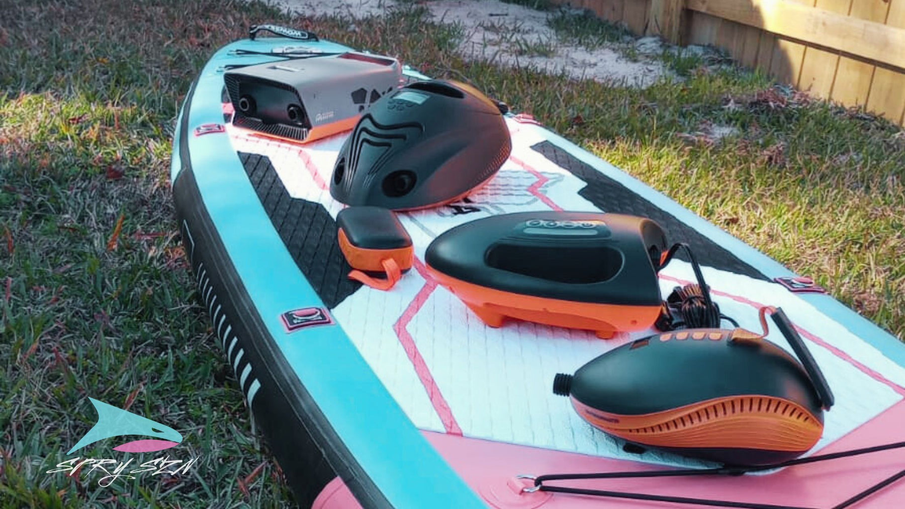 What Outdoor Master electric SUP pump should I buy? Four pumps and one portable power bank on top of a WOWSEA Poseidon P1 Inflatable and affordable paddle board with the SPRY SZN logo on the bottom left.