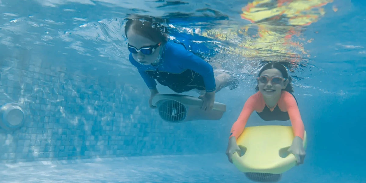 Two kids using Asiwo Mako Electric Kickboards underwater.