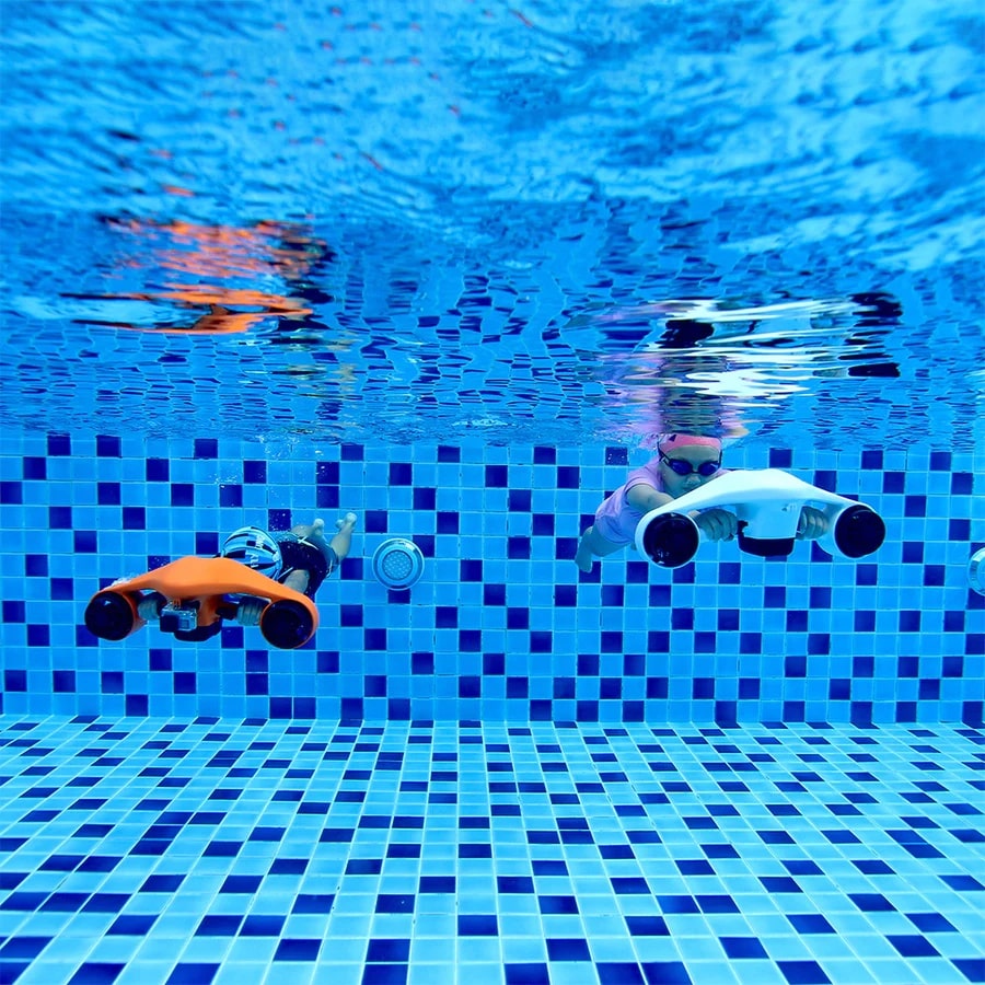 Two kids going underwater with Asiwo Manta sea scooters in pool.