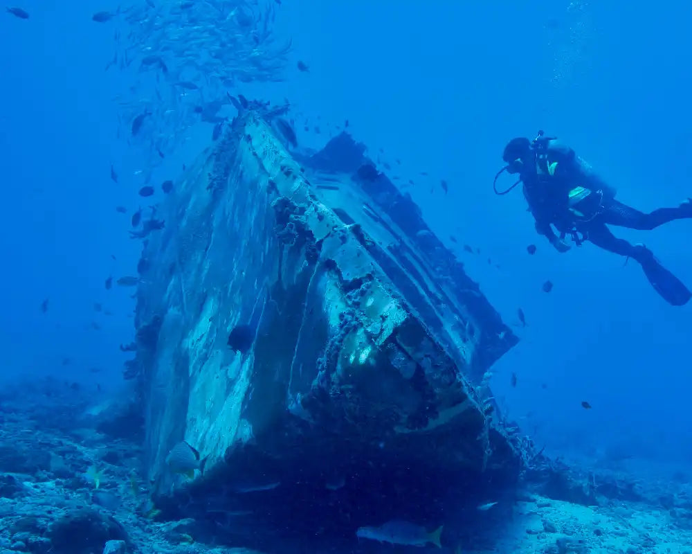Underwater wreckage diving with scuba diver.
