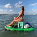 Squatch and Siren Sea Sleigher moray green inflatable dive raft with cooler and adult sitting on top of it.