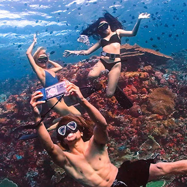 Best underwater phone case for wide-view selfies. The Sublue H1 Plus is being used to take a selfie of three adults in the ocean.